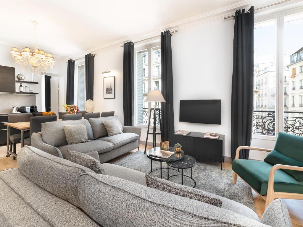un salon avec un canapé et une télévision dans l'établissement LivinParis - Luxury 3 Bedrooms Le Louvre I, à Paris