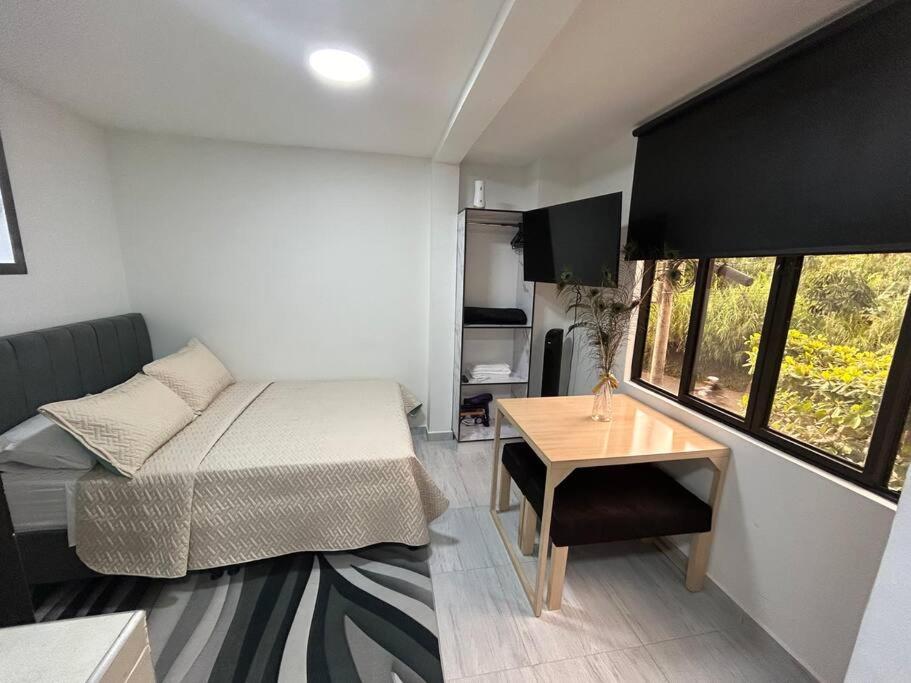 MatecanaにあるHermoso Aparta Estudio 7 minutos del Aeropuertoのベッドとテーブルのある小さな寝室