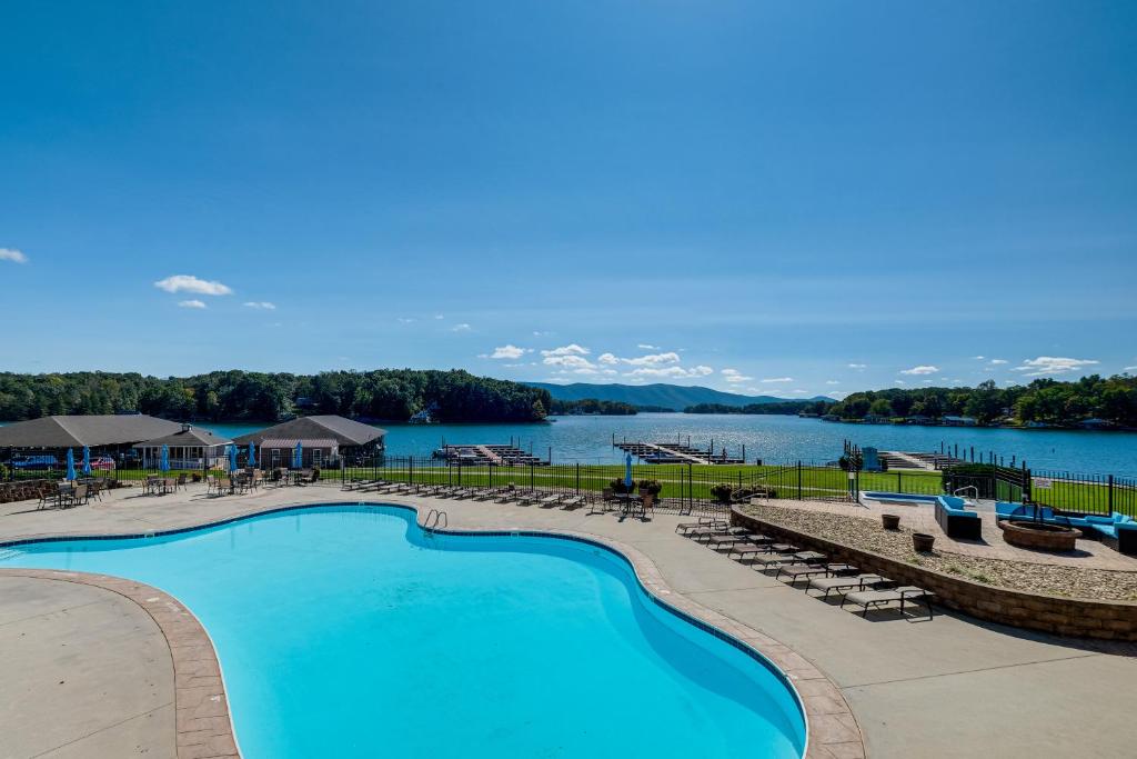 a swimming pool with a view of a lake at Beach and Pool Access Smith Mountain Lake Getaway! in Huddleston