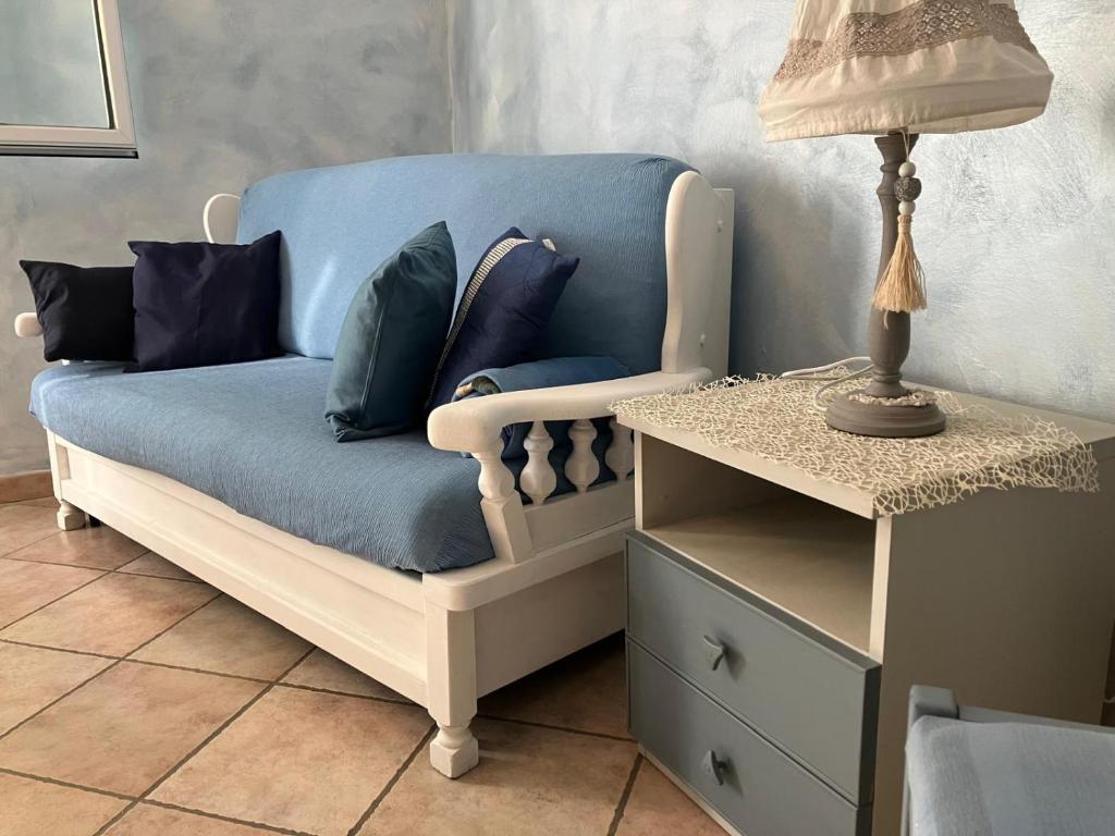 a blue couch with pillows on it next to a table at Stillness Valley - La Casa nella Valle della Quiete in San Mauro Torinese