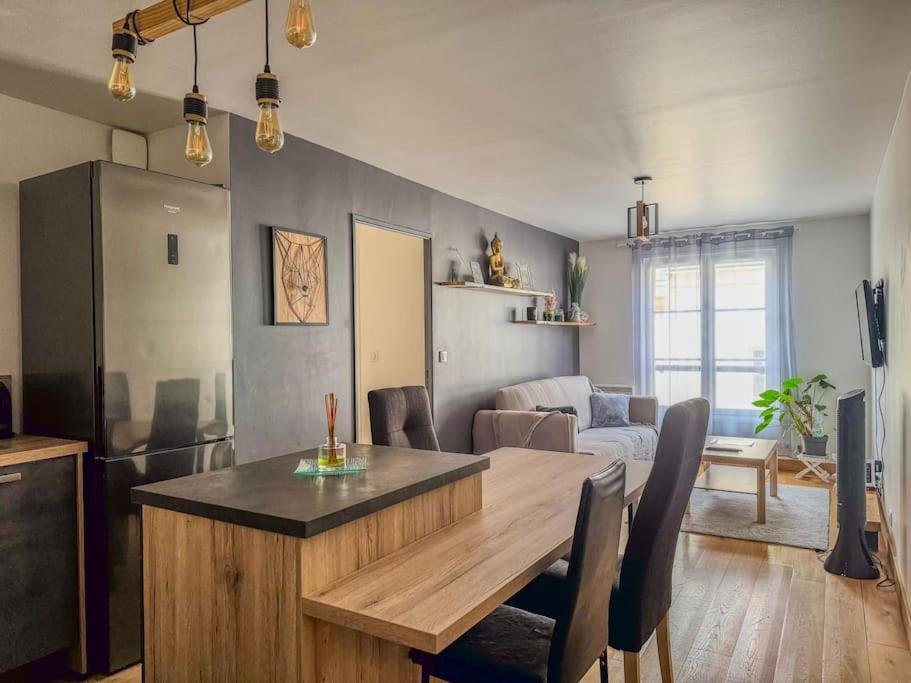 une cuisine et un salon avec une table et des chaises dans l'établissement Appartement moderne dans le centre de Chartres, à Chartres
