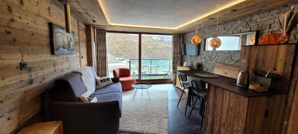a living room with a couch and a bar in a house at Grands studios vue sur lac in Tignes