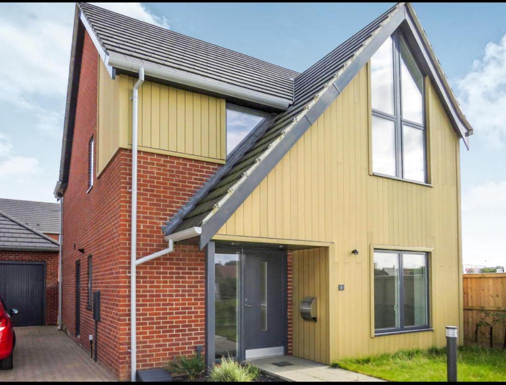 a yellow house with a red brick at Manor Park View in Norwich
