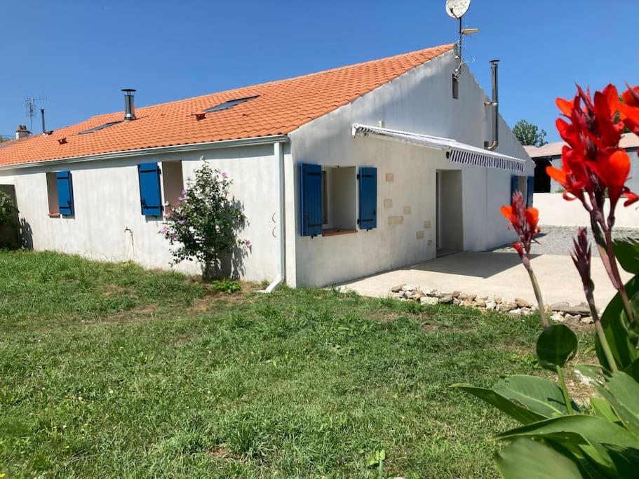 une maison blanche avec des fenêtres bleues et une cour dans l'établissement Maison proche de la mer!, au Perrier