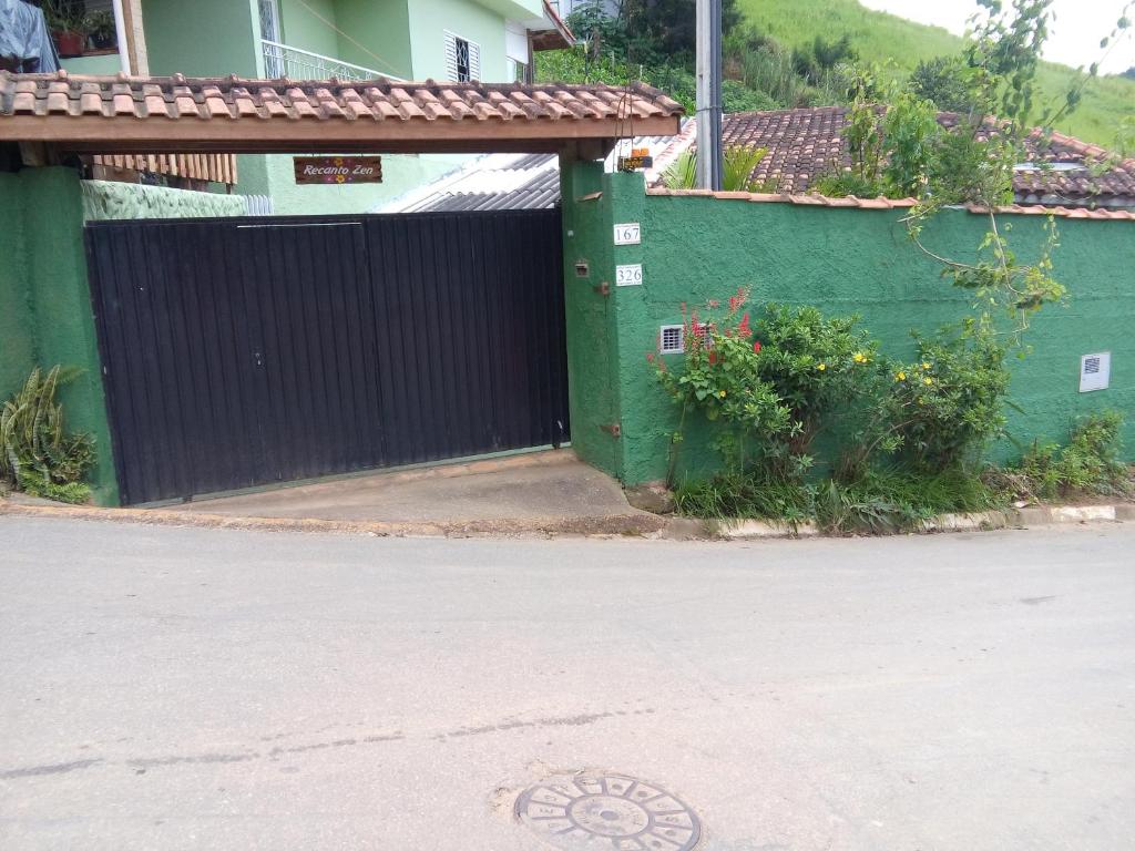 un edificio verde con una puerta en una calle en Casa e Suíte Recanto Zen, en Santo Antônio do Pinhal