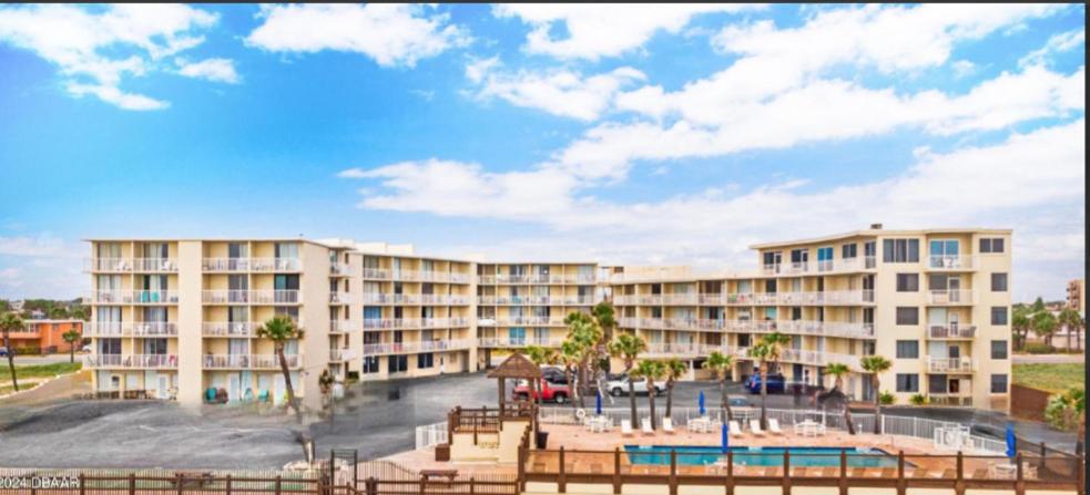 a large apartment building with a playground in front of it at Superior beach studio with Pool Access and free parking in Daytona Beach