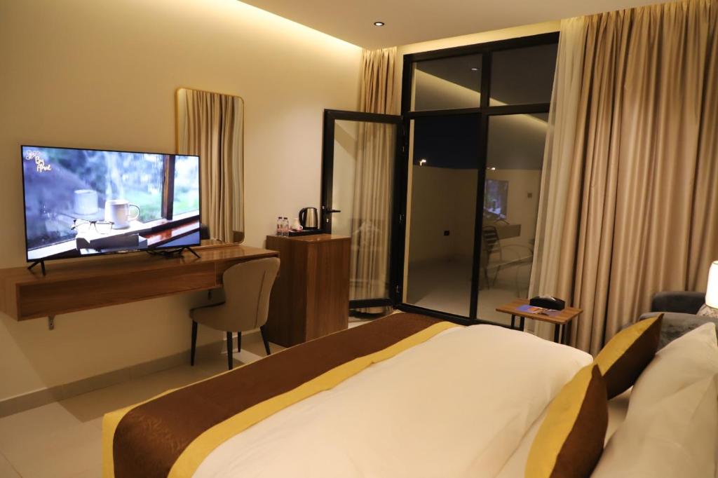 a hotel room with a bed and a desk and a television at افال للشقق المخدومة -المونسية in Riyadh