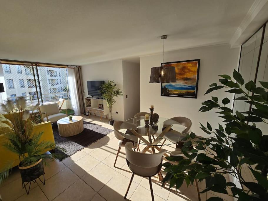 a living room with a table and some plants at Hermoso Departamento Equipado por Días in Arica