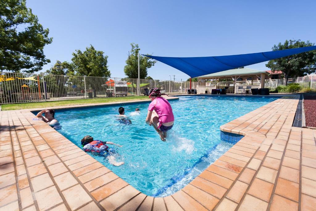 un grupo de personas jugando en una piscina en NRMA Dubbo Holiday Park, en Dubbo