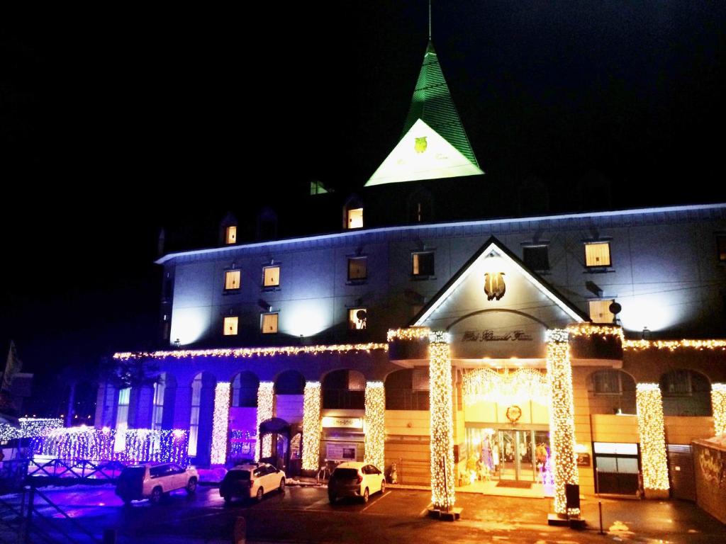 a large building with christmas lights in front of it at Hotel Naturwald Furano in Furano