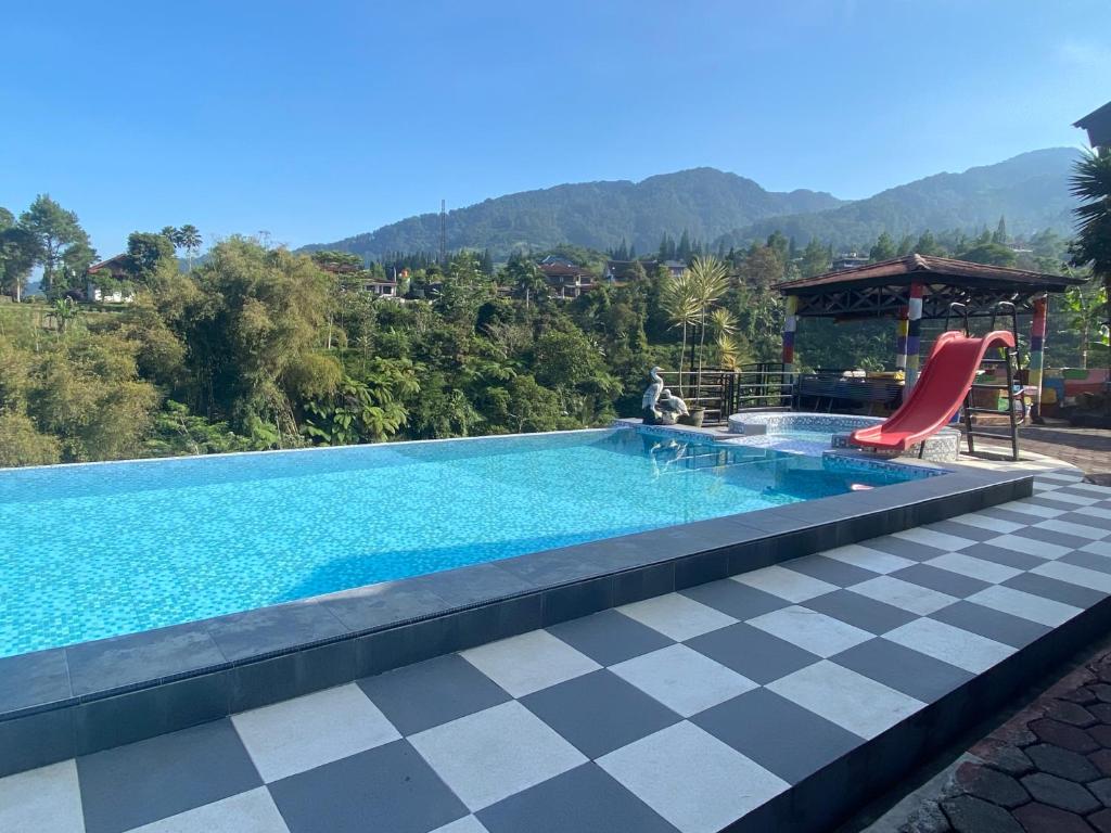 una piscina con suelo a cuadros y un tobogán rojo en Villa puncak6, en Campaka