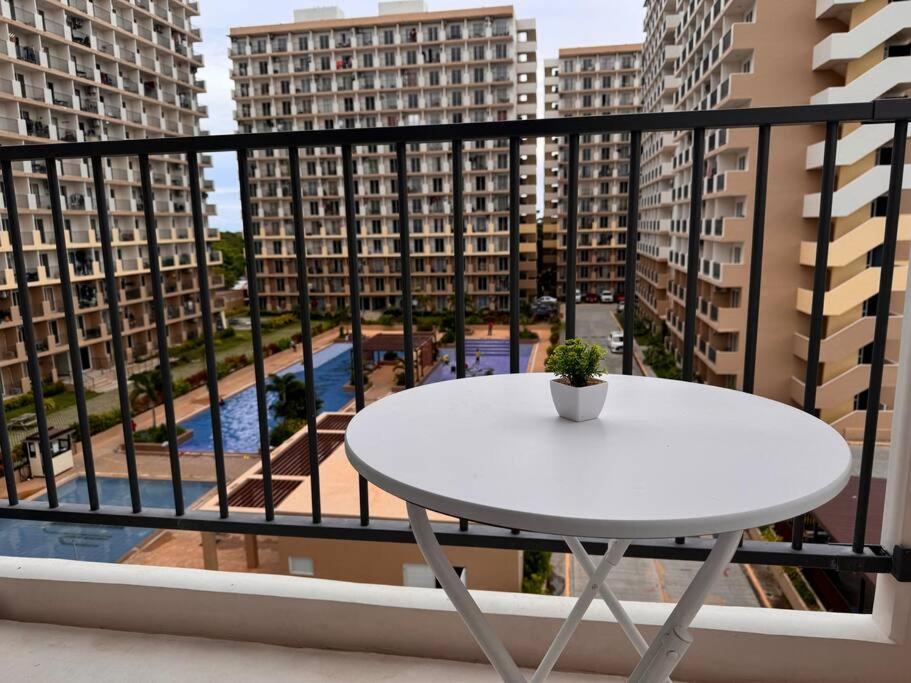 a white table on a balcony with tall buildings at Claire's Empire in Lapu Lapu City