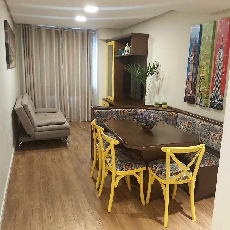 a living room with a dining room table and chairs at Apartamento aconchego in Gramado