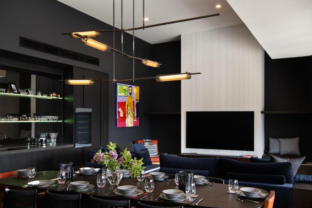a dining room with a table and a projection screen at Chalet Noir - sleek design with heated plunge pool in Daylesford