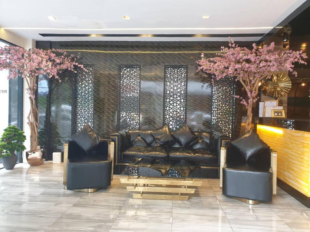 a lobby with a leather couch and two chairs at Sakura Sky Residence in Bangkok
