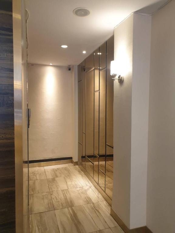 a hallway with a elevator and a glass door at Sakura Sky Residence in Bangkok