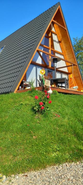 a gazebo with some flowers in the grass at Wood & Bricks Chalet in Giuleşti