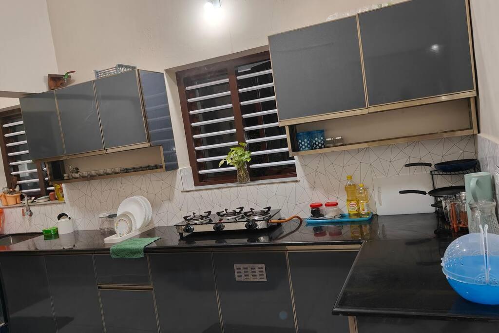 a kitchen with stainless steel cabinets and a stove at inactive Krishnarpanam 2BHK villa in Guruvayoor in Guruvāyūr