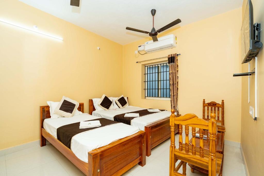 a bedroom with two beds and a window at Hotel Balaji Rameswaram in Rāmeswaram