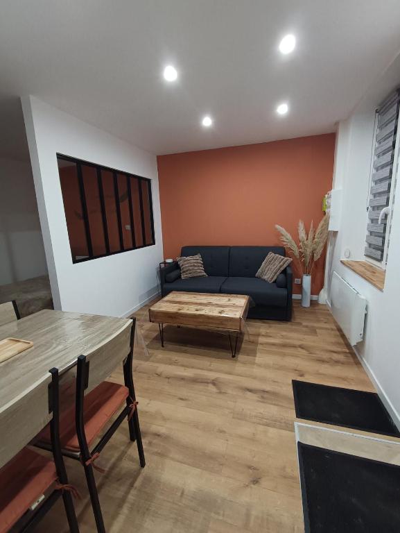 un salon avec un canapé et une table dans l'établissement Appartement cosy à Chamagne, à Chamagne