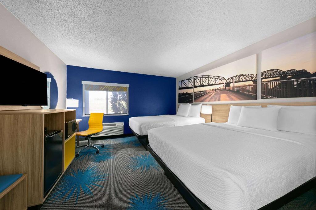 Una habitación de hotel con dos camas y un televisor de pantalla plana. en Days Inn by Wyndham Fort Smith, en Fort Smith