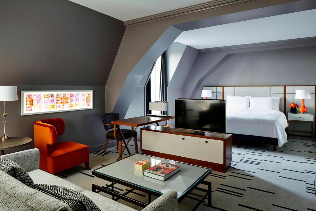 a bedroom with a bed and a living room with a tv at London Marriott Hotel County Hall in London