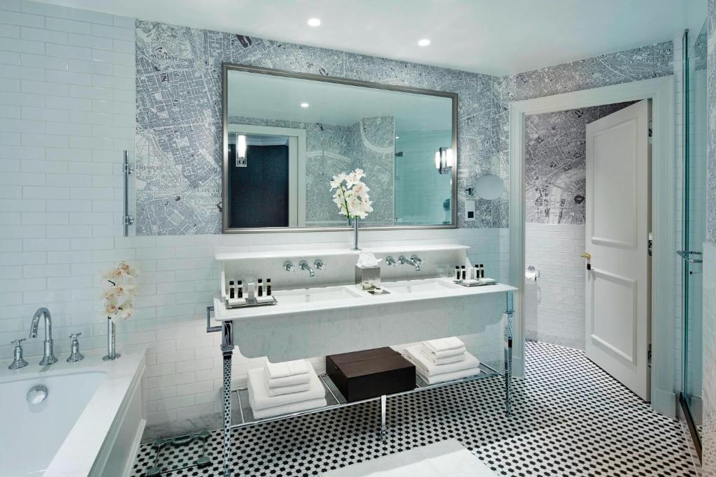 a bathroom with a large sink and a tub and a mirror at London Marriott Hotel County Hall in London