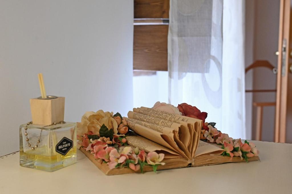 un tavolo con un libro aperto e una candela e fiori di Civico 1 a Oria