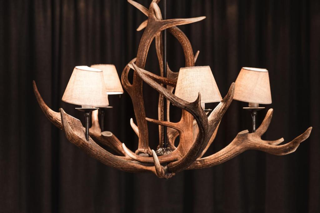 a chandelier with antlers and three candles at Anthony's Life&Style Hotel in Sankt Anton am Arlberg