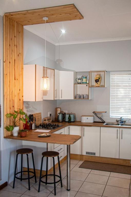 a kitchen with white cabinets and a wooden counter top at Marilyn's Cottage in White River