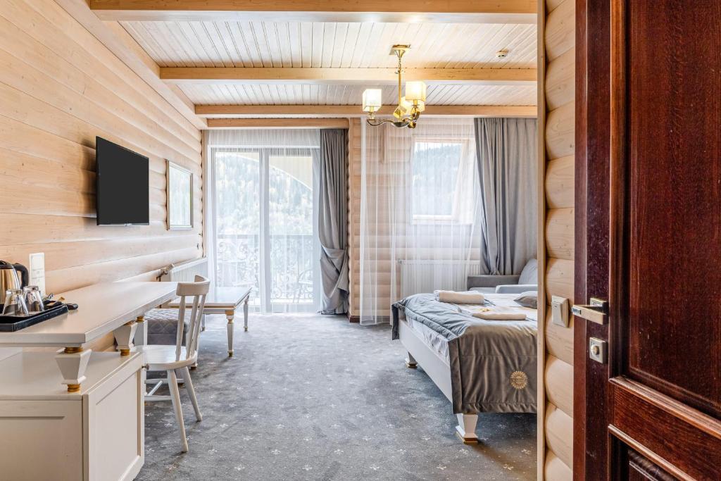 a bedroom with a bed and a desk in a room at MARION SPA Hotel & Spa - RENOVATION - Rooms, SPA area, Swimming pool, Reception, Restaurant, Lounge Bar, Hookah bar, Children's room, Parking, SPA and Breakfast included in the price in Bukovel