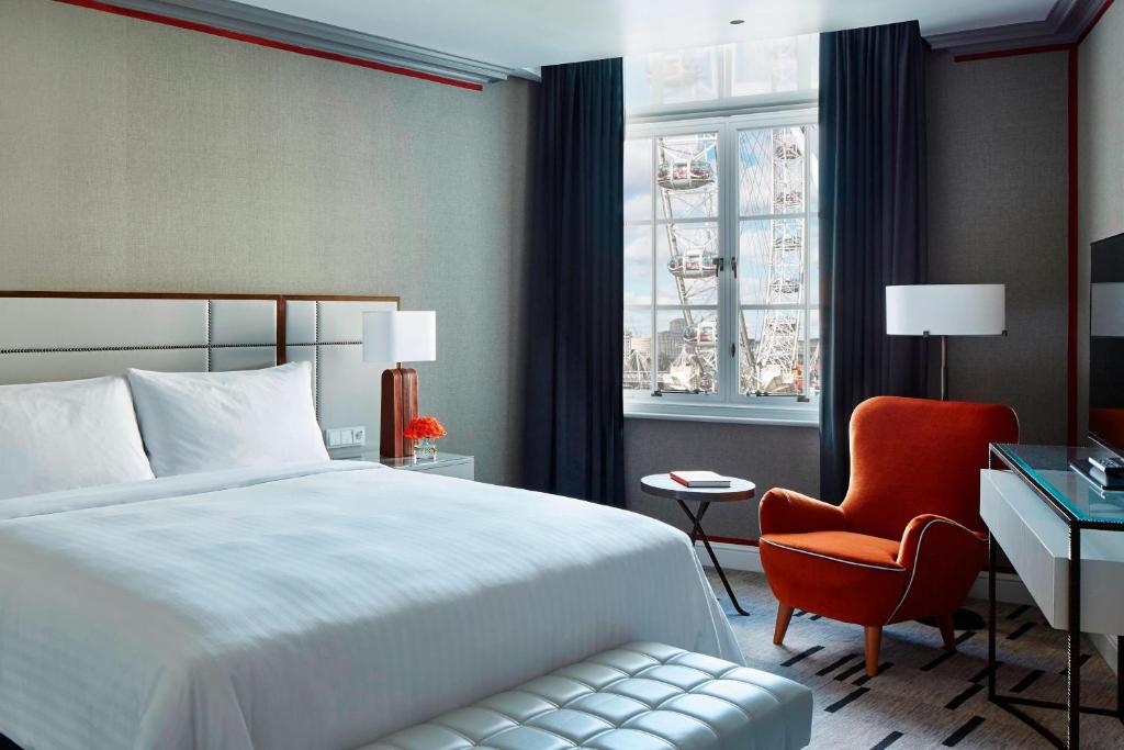 a bedroom with a bed and a chair and a desk at London Marriott Hotel County Hall in London
