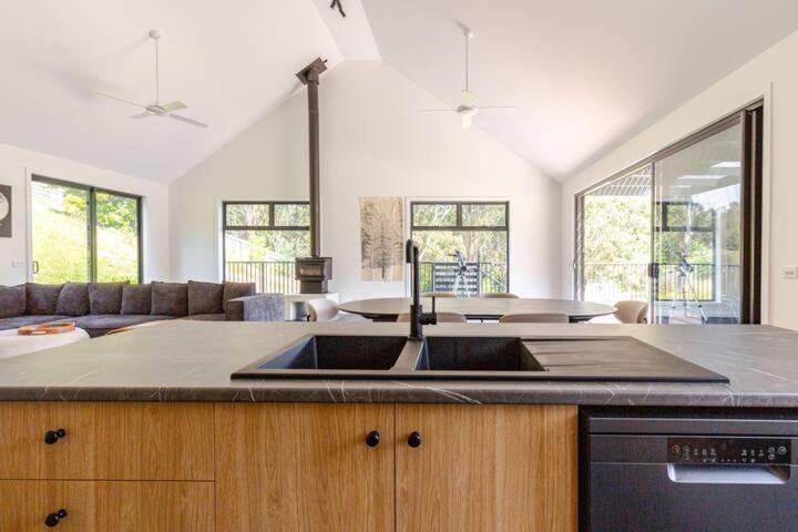 Una cocina con fregadero y una sala de estar. en Kennys Cottage, en Metung