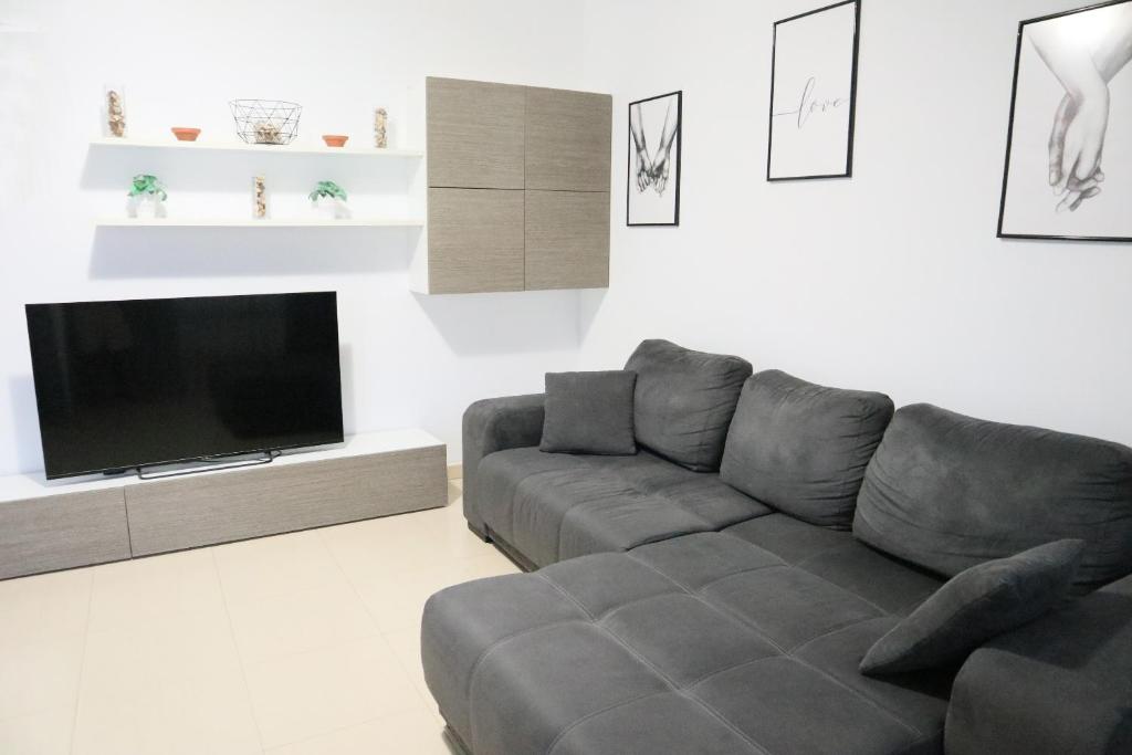 Una sala de estar con un sofá y un televisor de pantalla plana. en HAPPY FLAT TENERIFE, en San Isidro