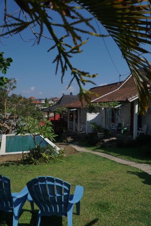 a yard with a blue chair and a house at Berawagaya Bungalows in Dalung