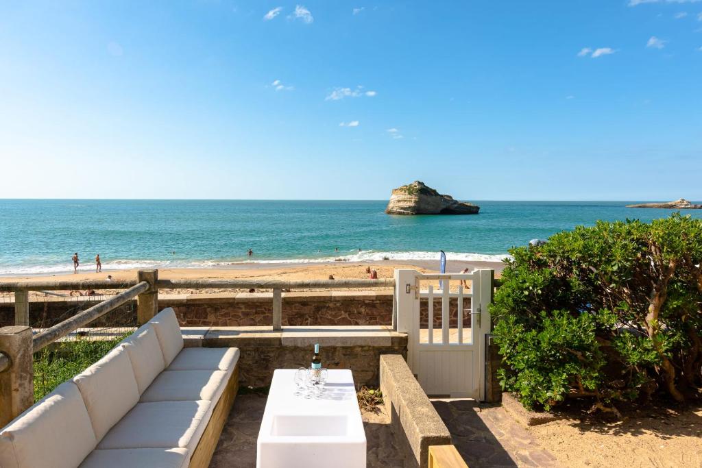 Cette chambre offre une vue sur une plage dotée d'un banc et l'océan. dans l'établissement AROHA Apt with terrasse and sea view in Biarritz, à Biarritz