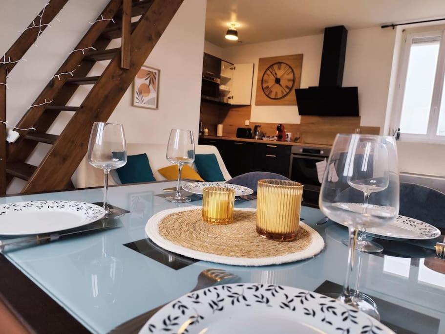 une table avec des assiettes et des verres à vin dessus dans l'établissement Duplex - Proche Gare & Centre, à Compiègne