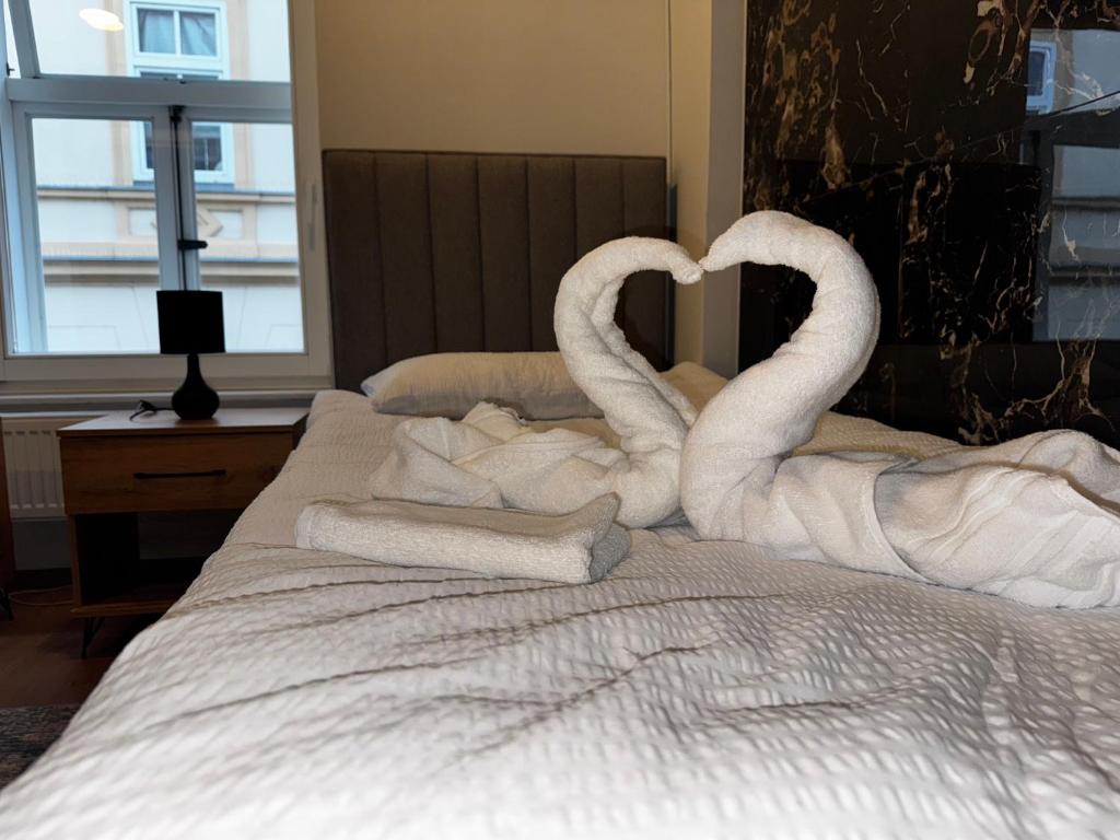 two swans making a heart on a bed at Šeherezada Rooms in Ljubljana