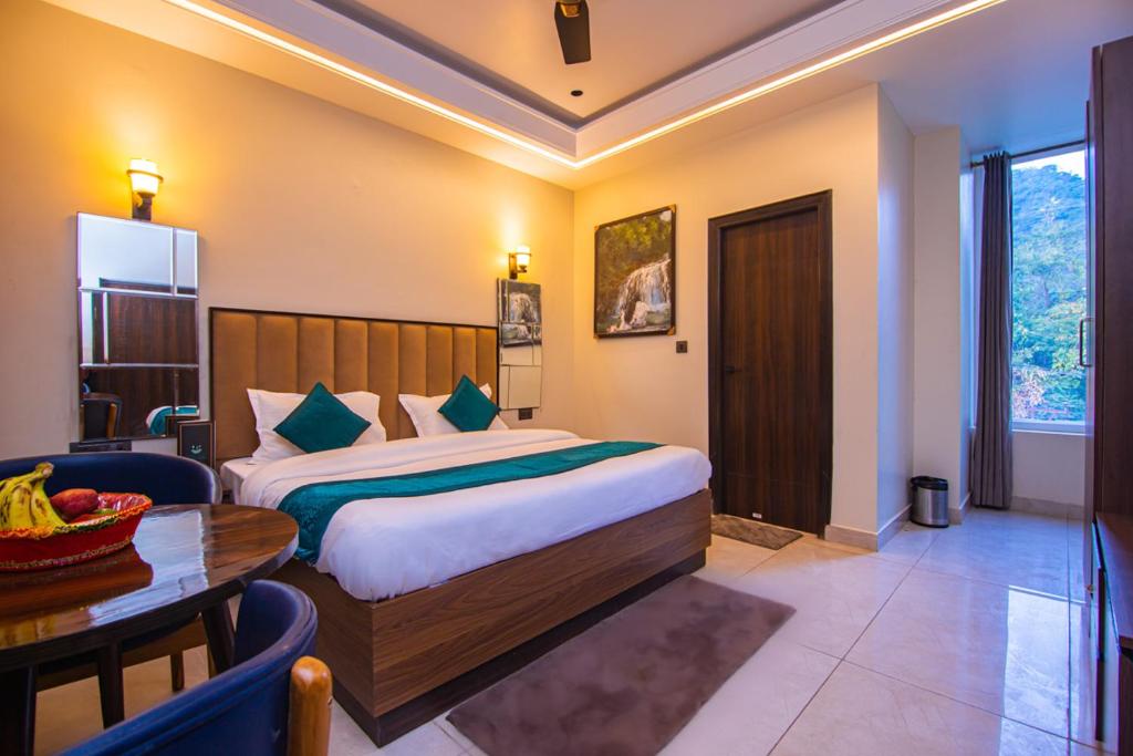een hotelkamer met een bed en een tafel bij Hotel Lords Valley Rishikesh in Rishīkesh