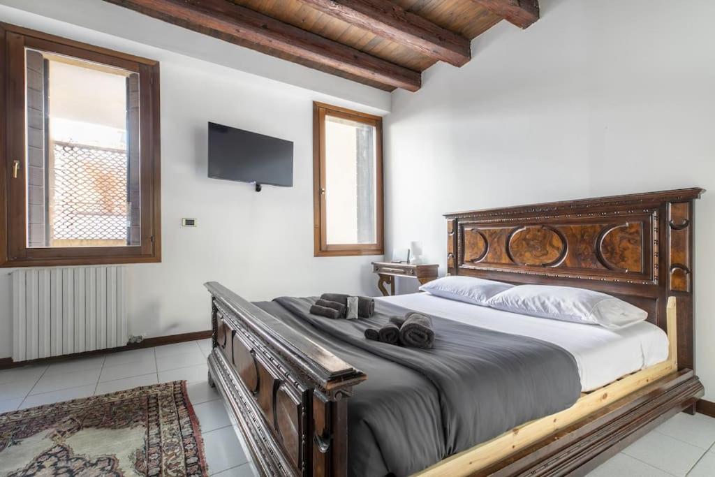 a bedroom with a large bed with a wooden headboard at i-HOMES JuniorSuite Centro Padova in Padova
