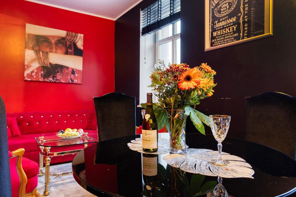 een eetkamer met een tafel met een vaas met bloemen bij Apartamenty Firfas 2 in Bydgoszcz