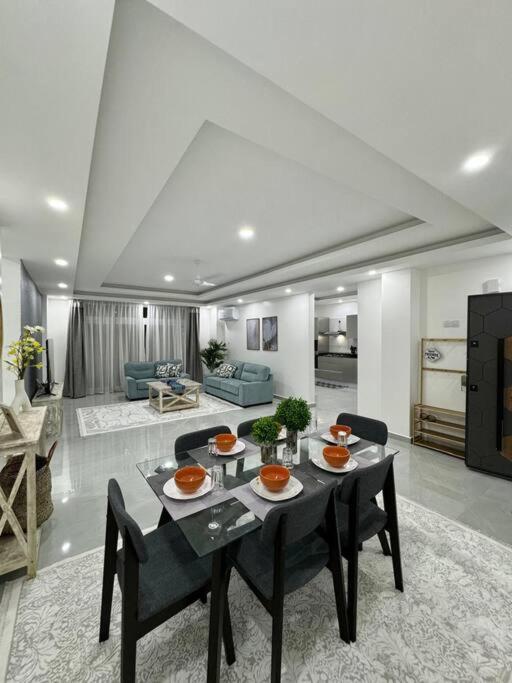 a dining room with a table and chairs in a living room at Azure 4bdrm beachfront at jumeirah palm resort nyali in Bamburi