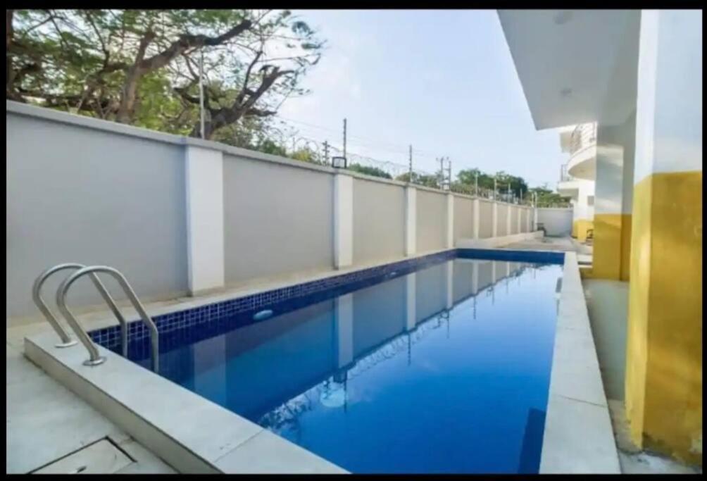 a swimming pool with blue water in a building at Azure 3bdrm beachfront at jumeirah palm resort nyali in Bamburi