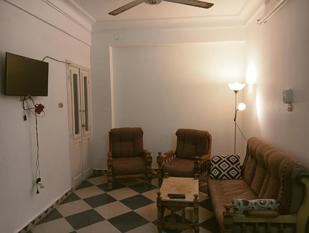 a living room with two chairs and a flat screen tv at لؤلؤه الفيروز in Marsa Matruh