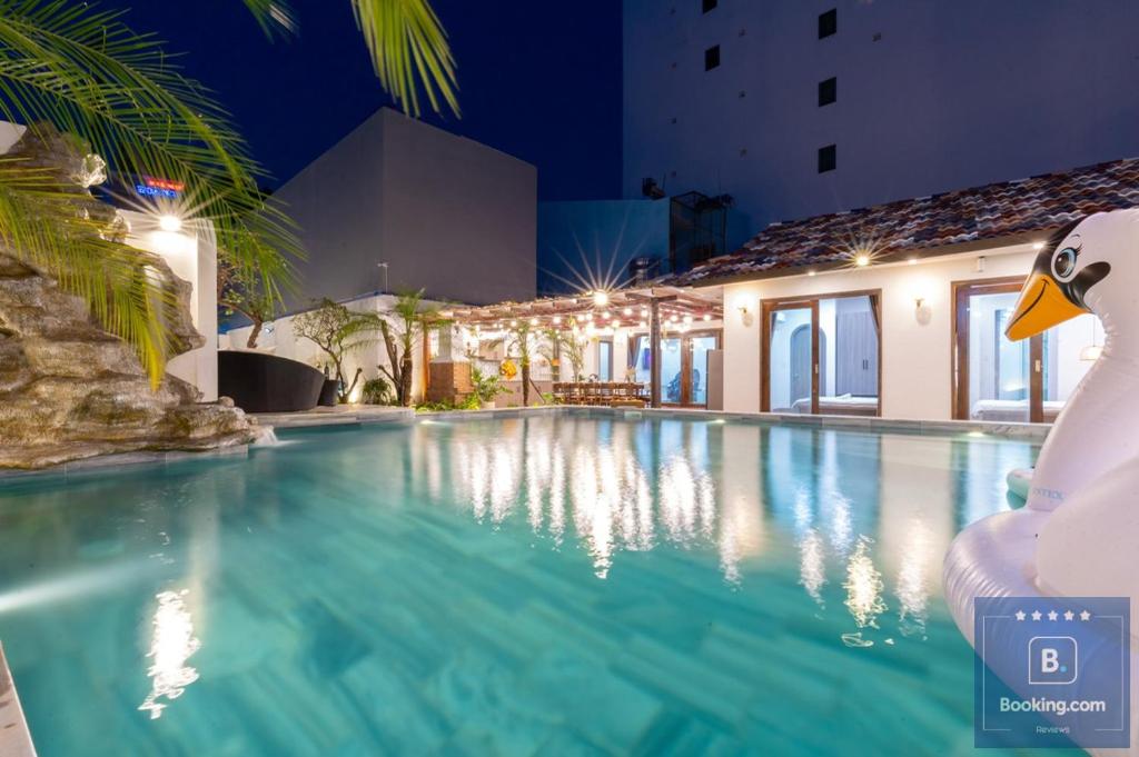 une piscine la nuit avec un canard au premier plan dans l'établissement Cối Xoay Gió Trệt Không Lầu - 6 Phòng Ngủ - Bida - Karaoke Phòng Lạnh - Gần Biển Bãi Sau Vũng Tàu, à Vung Tau