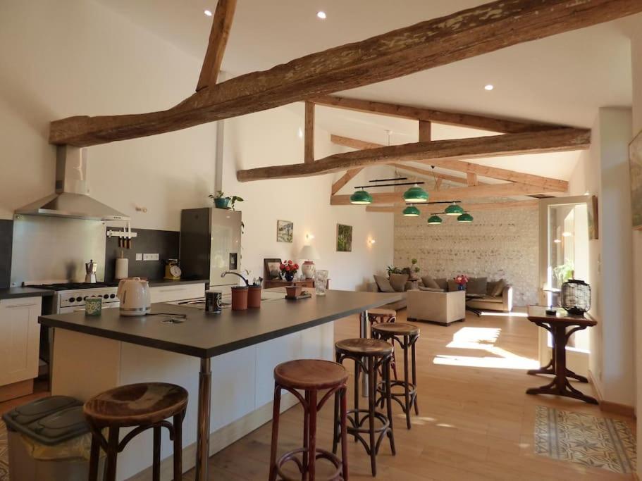 une cuisine avec un grand îlot et des tabourets de bar dans l'établissement Maison de vacances ideale - La Mariniere du Mesnil, à Le Mesnil