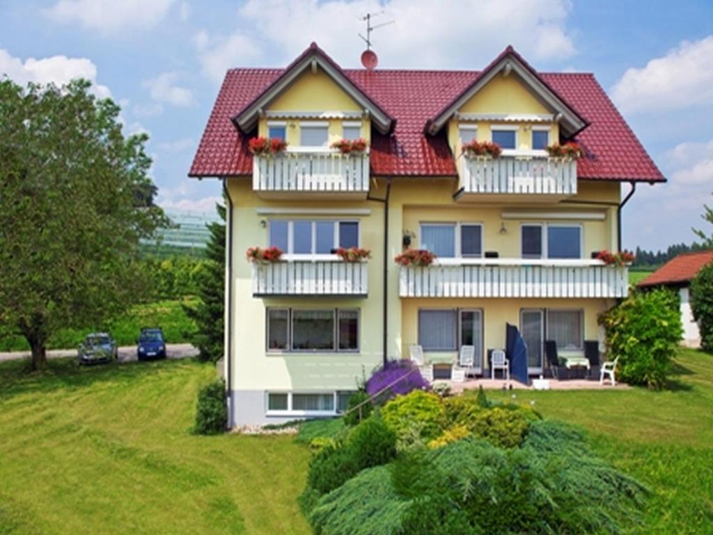 una casa amarilla con techo rojo en Landhaus Erben, en Wasserburg