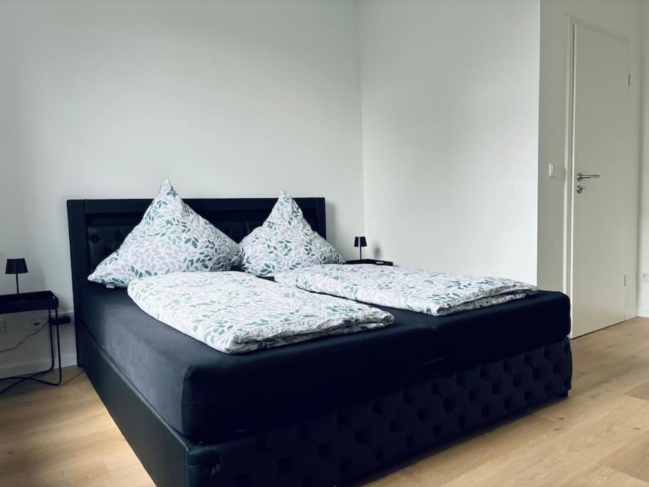 a black bed with pillows on top of it at Große 80qm Wohnung mit mehreren Zimmern in Essen