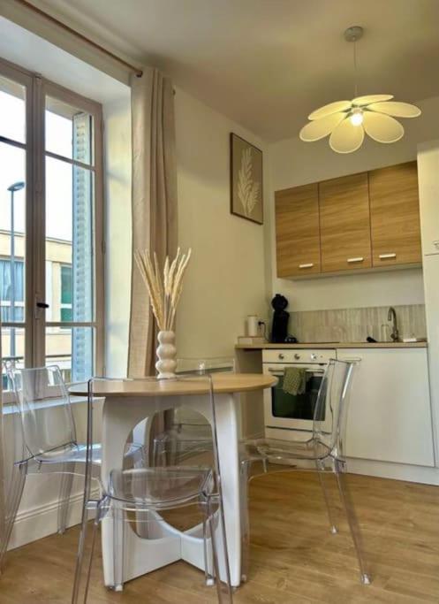 une cuisine avec une table et des chaises dans une pièce dans l'établissement Le petit Rameau - T2 hypercentre, à Clermont-Ferrand