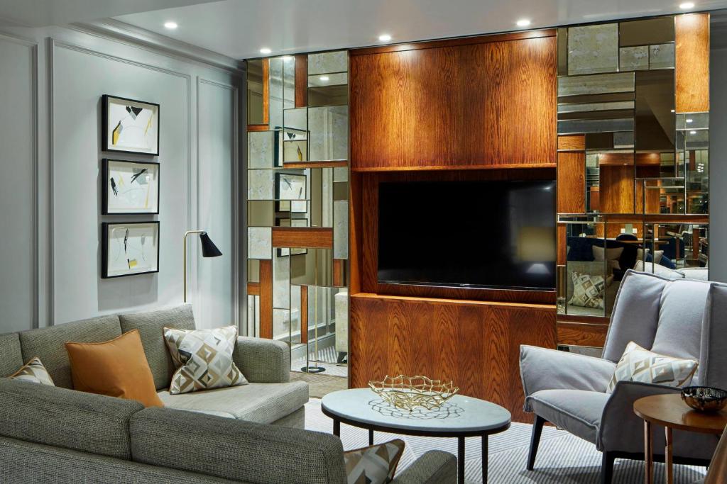 a living room with a couch and a flat screen tv at London Marriott Hotel County Hall in London